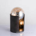 Metal cylindrical base supports glass ball desk lamp